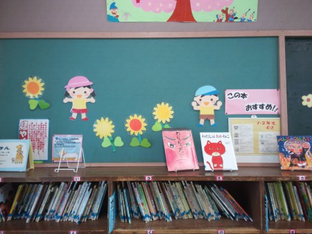 低学年図書室。壁面の男の子、女の子が夏服に衣替えしました。
